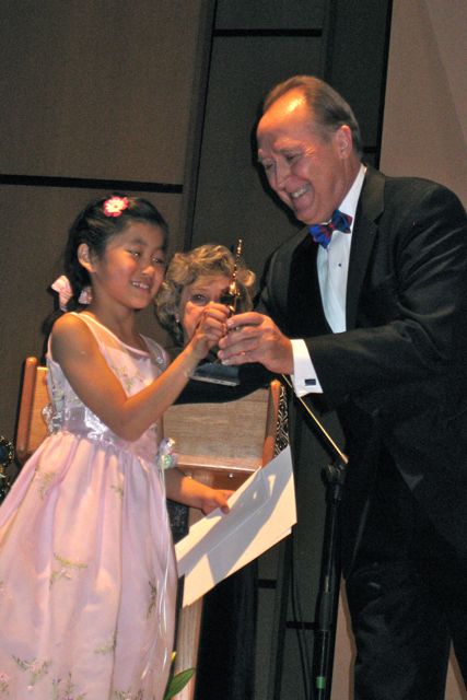 Anna  Yakura gets her 1st place trophy, cash award, and diploma at the Winner's Concert on Sunday